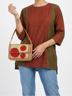 Woman holding a beaded handbag with tomato design against a white background