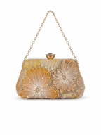 A beige clutch bag with floral design, pearls and chain strap on a white background